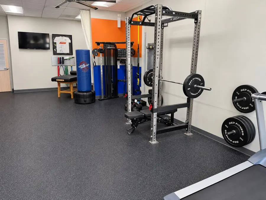 The strength training floor at Sports Lab Cinco Ranch: power rack, cable machine and stretch table